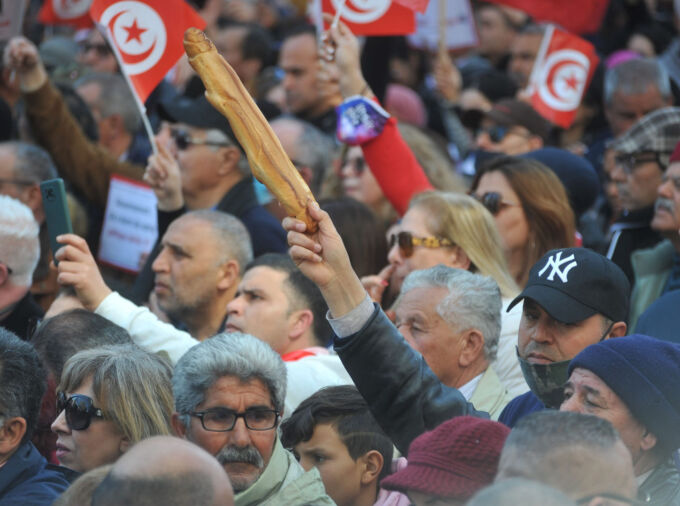 Crowd of people holding Tunisian flags