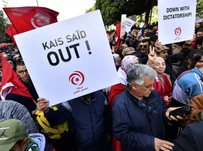 Tunisian demonstrators carry placards during protest